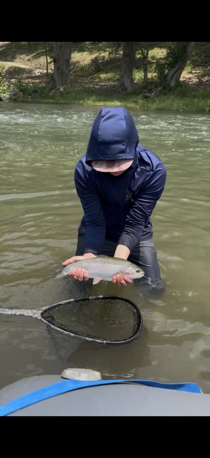 Wading angler with a rainbow trout